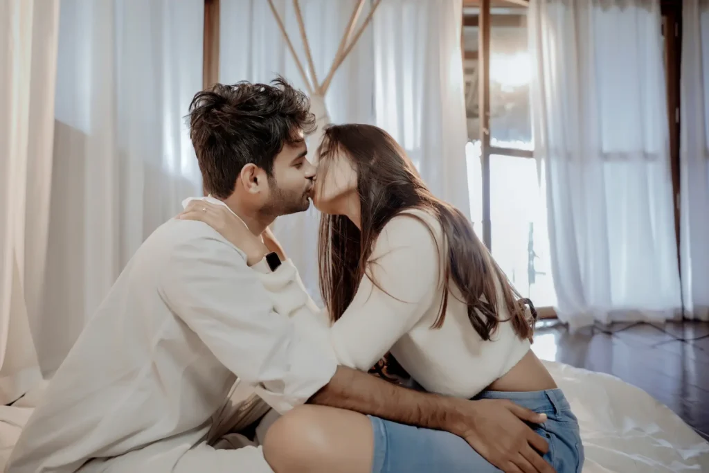 Joyful couple kissing in cozy resort setting at Varkala